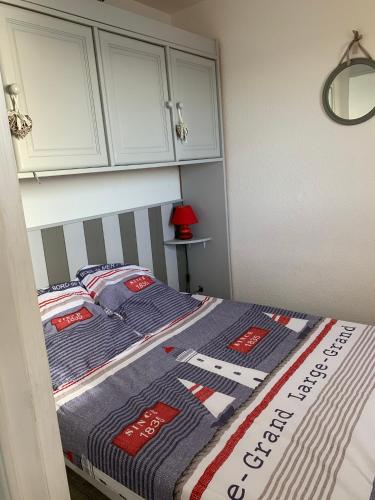 - un lit avec une couverture bleue et rouge dans l'établissement TRÈS BELLE VUE, à Leucate