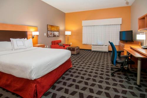 a hotel room with a bed and a desk and a computer at TownePlace Suites by Marriott Baton Rouge Gonzales in Gonzales