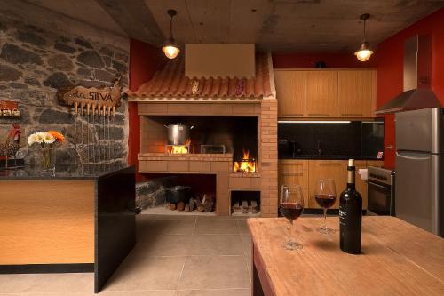 a kitchen with a table with two glasses of wine at KING´S HOUSE (Sea View and Indoor BBQ) in Estreito da Calheta