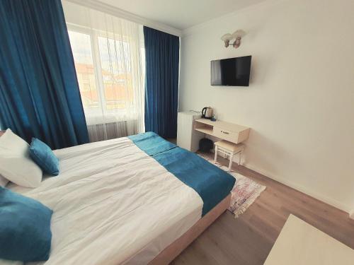 a bedroom with a bed and a desk and a television at Guest House Kolev - central in Nesebar