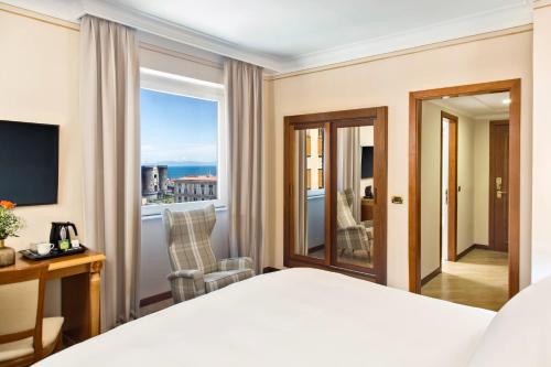 a hotel room with a bed and a balcony at Renaissance Naples Hotel Mediterraneo in Naples