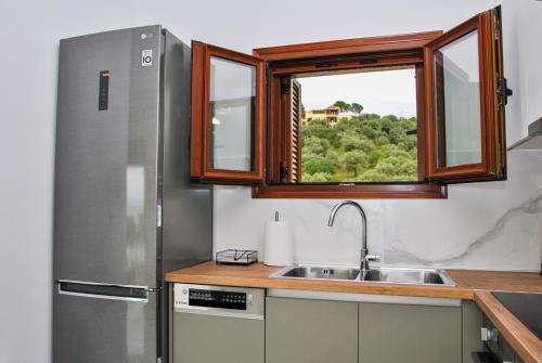 a kitchen with a sink and a window at Villa Oliveto con vista in Lefkada