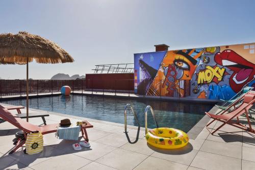 - une piscine avec une fresque murale sur le côté d'un bâtiment dans l'établissement Moxy La Ciotat, à La Ciotat