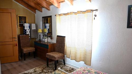 sypialnia z 2 krzesłami, biurkiem i zasłoną w obiekcie Vila Topalli w mieście Pogradec