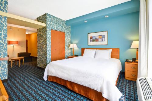 Cette chambre d'hôtel dispose d'un grand lit et de murs bleus. dans l'établissement Fairfield Inn and Suites by Marriott Birmingham Fultondale / I-65, à Fultondale