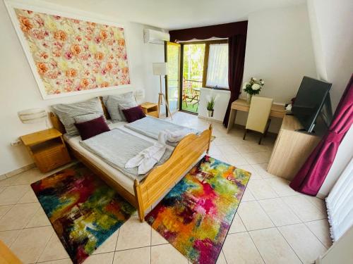 a bedroom with a bed on a colorful rug at Villa Peonia in Keszthely