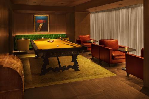 a room with a pool table and a green couch at The Barcelona EDITION in Barcelona
