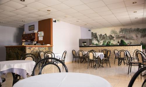 un comedor con mesas, sillas y una barra en Petania Hotel & Apartments, en Lixouri