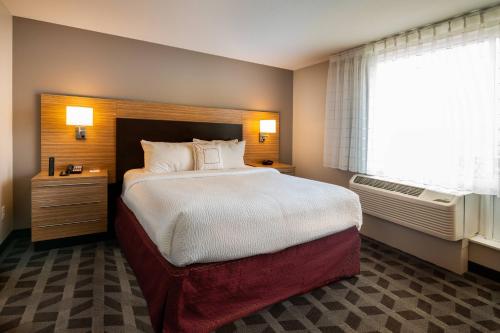 橡樹溪的住宿－TownePlace Suites by Marriott Milwaukee Oak Creek，一间卧室设有一张大床和一个窗户。
