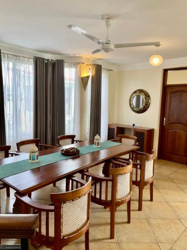 a dining room with a large wooden table and chairs at Villa Macheo in Mombasa