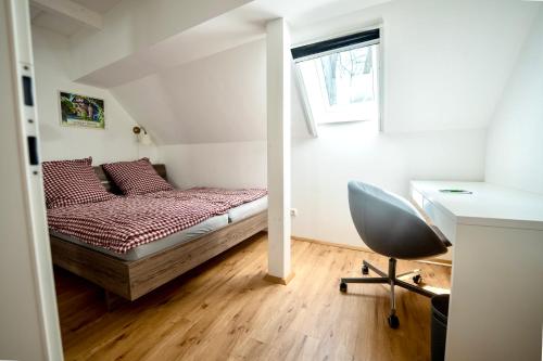 a bedroom with a bed and a desk and a chair at Schilcherland Lodge in Greisdorf