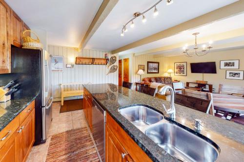 a kitchen with a sink and a living room at Snowmas Village 20C in Snowmass Village
