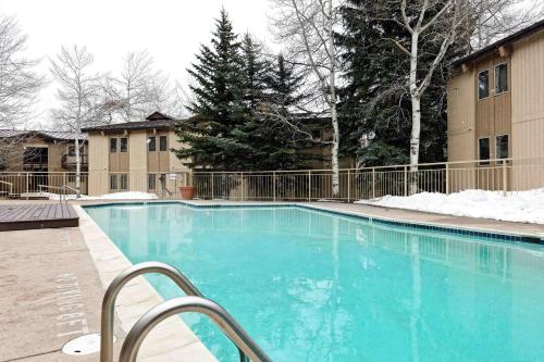 a large blue swimming pool with snow on the ground at Snowmas Village 20C in Snowmass Village
