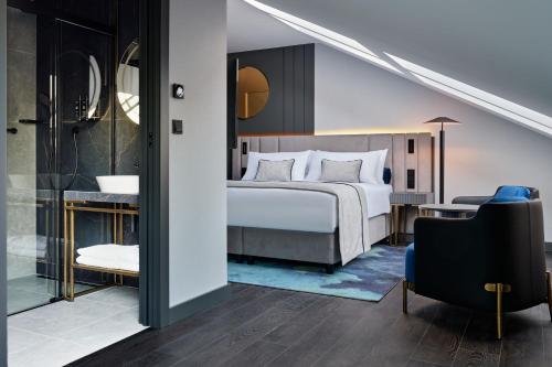 a bedroom with a bed and a desk with a chair at Garamond a Tribute Portfolio Hotel in Kraków