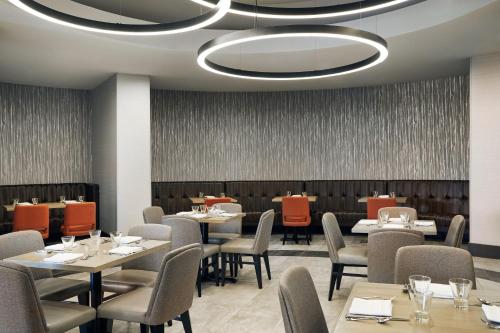 a dining room with tables and chairs and a ceiling at Chicago Marriott Oak Brook in Oak Brook