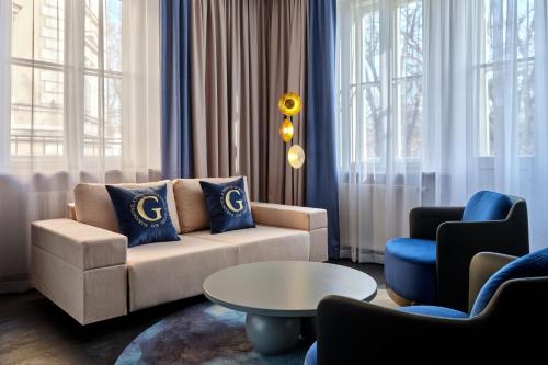 a living room with a couch and a table at Garamond, a Tribute Portfolio Hotel, Krakow Old Town in Kraków
