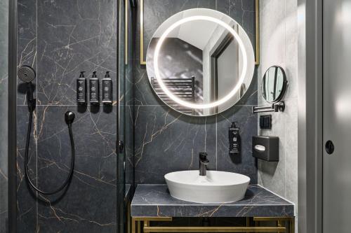 a bathroom with a sink and a mirror at Garamond, a Tribute Portfolio Hotel, Krakow Old Town in Kraków