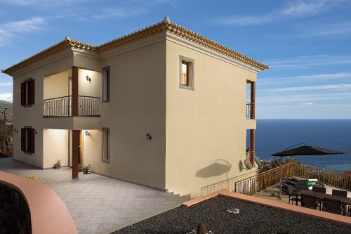 a large white house with a view of the ocean at KING´S HOUSE (Sea View and Indoor BBQ) in Estreito da Calheta