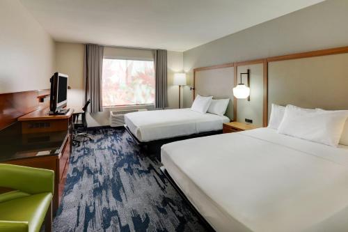 a hotel room with two beds and a television at Fairfield Inn by Marriott Las Colinas in Irving