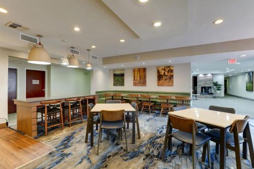 Fairfield Inn by Marriott Las Colinas في ايرفينغ: منطقة طعام مع طاولات وكراسي في مطعم