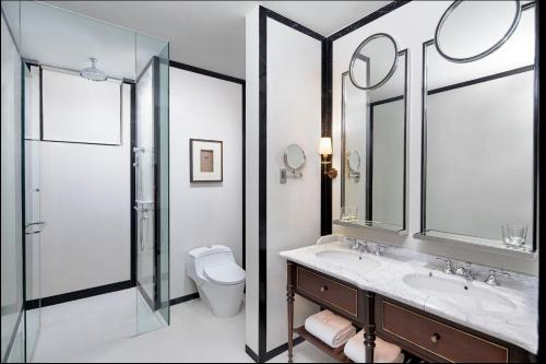a bathroom with a sink and a shower and a toilet at The Hermitage, A Tribute Portfolio Hotel, Jakarta in Jakarta