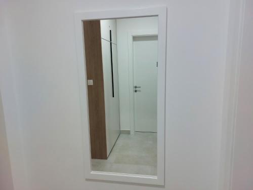 a mirror in a white room with a door at APARTMAN SONJA in Trebinje