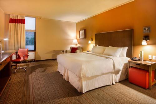 a hotel room with a large bed and a desk at Four Points by Sheraton Saltillo in Saltillo