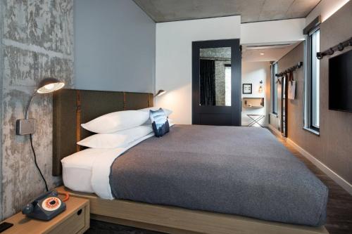 a bedroom with a large bed with white pillows at MOXY Seattle Downtown in Seattle