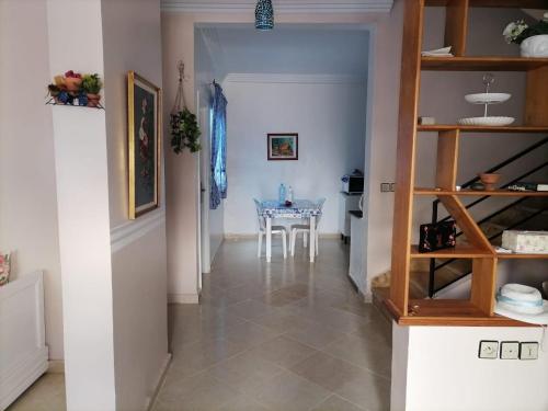 un couloir avec une table et une salle à manger dans l'établissement Maison Azul, à Saïdia