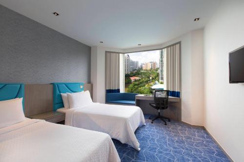 a hotel room with two beds and a window at Four Points by Sheraton Singapore, Riverview in Singapore