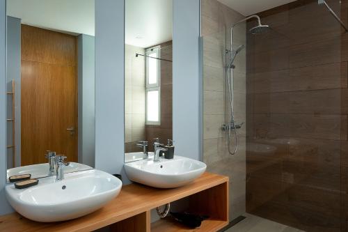 a bathroom with two sinks and a shower at King´s Paradise (Heated Pool and Sea View) in Estreito da Calheta