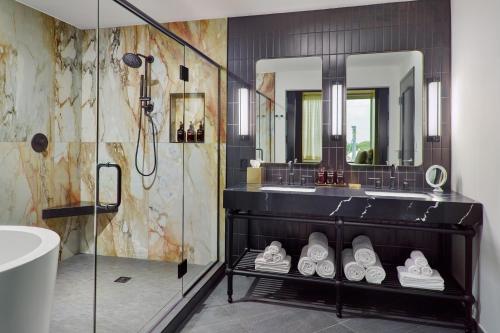 a bathroom with a walk in shower and a sink at Bellyard, West Midtown Atlanta, a Tribute Portfolio Hotel in Atlanta
