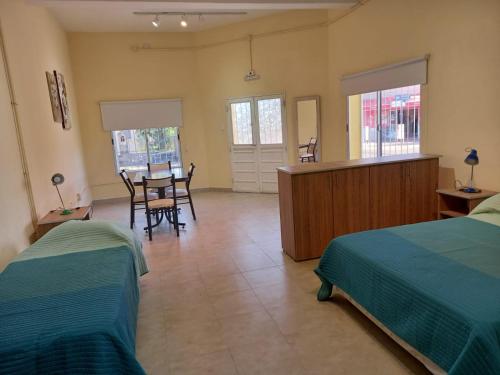 ein Schlafzimmer mit 2 Betten und ein Esszimmer mit einem Tisch in der Unterkunft MARGARITA ALOJAMIENTO TEMPORARIO in San Fernando del Valle de Catamarca