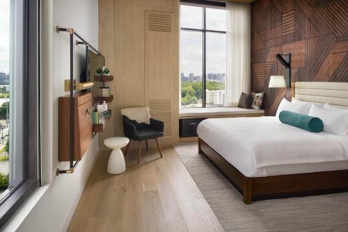 a bedroom with a bed and a chair and a window at Bellyard, West Midtown Atlanta, a Tribute Portfolio Hotel in Atlanta