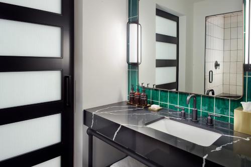 a bathroom with a sink and a mirror at Bellyard, West Midtown Atlanta, a Tribute Portfolio Hotel in Atlanta