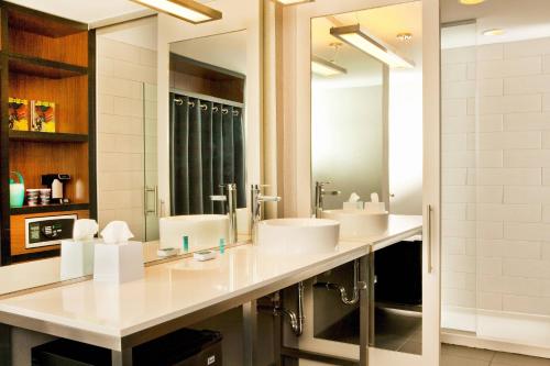 a bathroom with two sinks and a large mirror at Aloft Raleigh in Raleigh