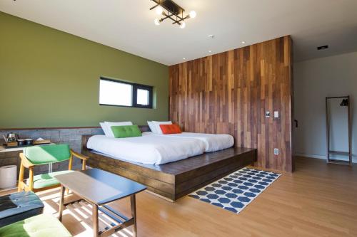 a bedroom with a large bed with a wooden wall at Jimi Stay in Jeju