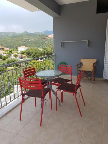 a patio with a table and chairs on a balcony at Eva's apartments in Nafpaktos
