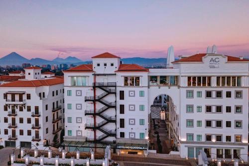 uma vista para um edifício branco com montanhas ao fundo em AC Hotels by Marriott Guatemala City em Guatemala