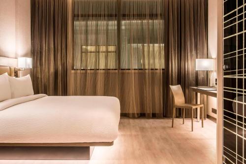 AC Hotels by Marriott Guatemala City tesisinde bir odada yatak veya yataklar