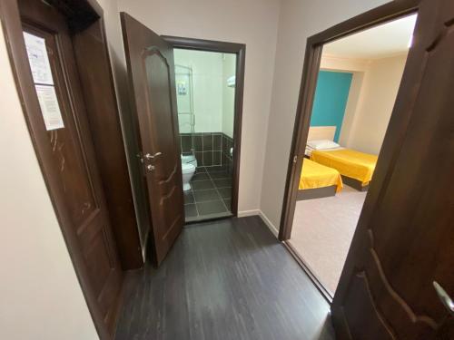 a bathroom with a mirror and a room with a bed at Ulpan Mini Hotel in Astana