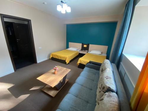 a living room with two beds and a couch at Ulpan Mini Hotel in Astana