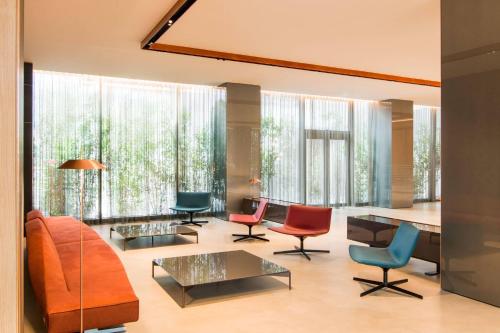 a living room with colorful furniture and large windows at Four Points by Sheraton Venice Mestre in Mestre
