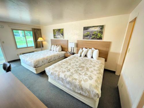 a hotel room with two beds and two windows at Alger Falls Motel in Munising