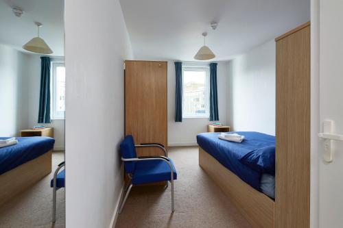 Cette chambre comprend 2 lits et un miroir. dans l'établissement Goldsmid House, Victoria, à Londres