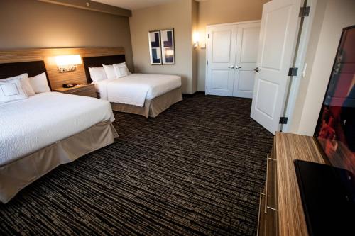 a hotel room with two beds and a tv at TownePlace Suites by Marriott Boynton Beach in Boynton Beach