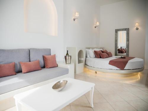 a living room with a bed and a couch at Anthemis Suites in Imerovigli