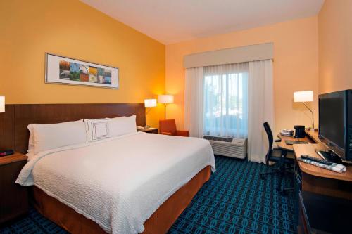 a hotel room with a bed and a desk and a television at Fairfield Inn and Suites by Marriott Tifton in Tifton