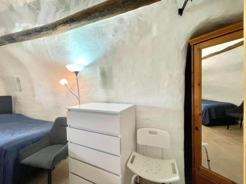 a bedroom with a bed and a dresser and a mirror at Cave House in Cúllar near Tabernas Desert in Margen de Abajo