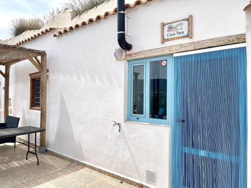 a white house with a blue door and a table at Cave House in Cúllar near Tabernas Desert in Margen de Abajo